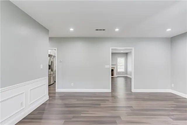 a view of empty room with wooden floor