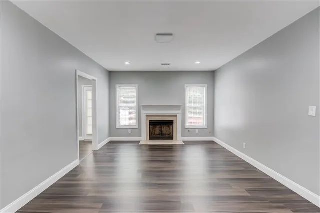 an empty room with wooden floor and fireplace