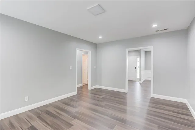 a view of an empty room with wooden floor