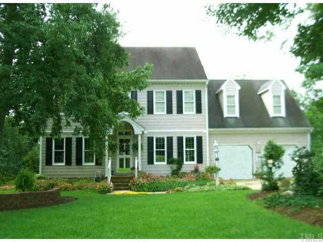 a front view of a house with a yard and potted plants