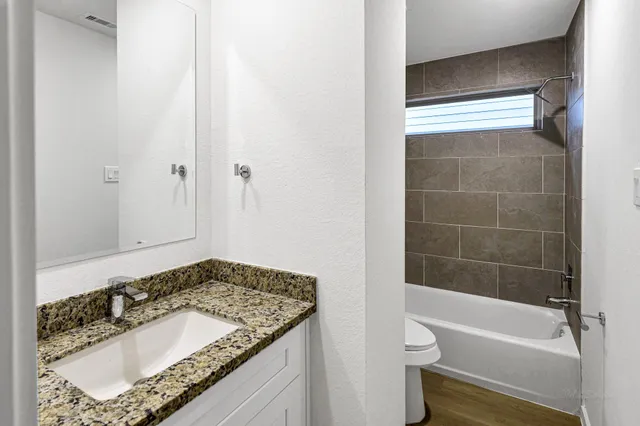 a bathroom with a granite countertop sink and a mirror