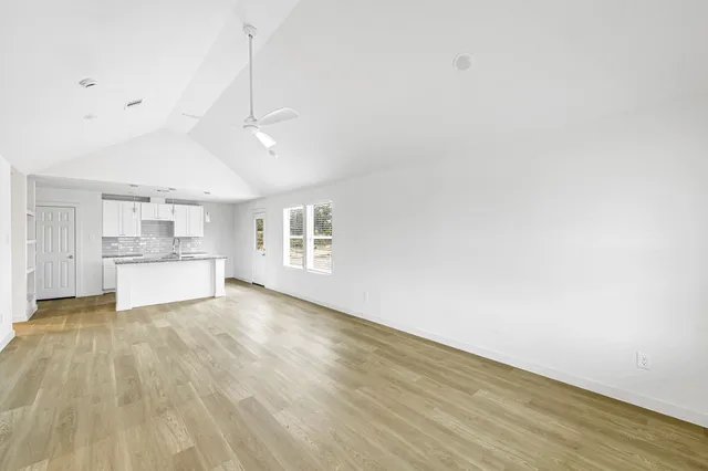 a view of a kitchen with wooden floor and a sink