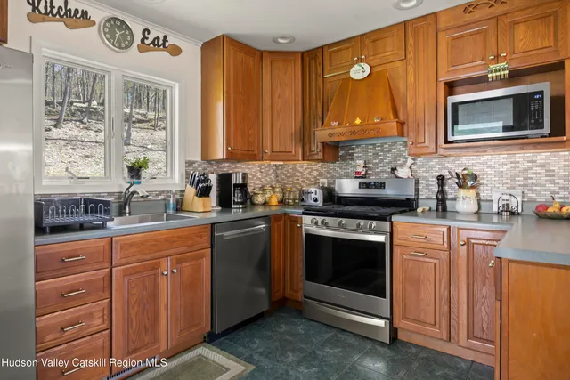 a kitchen with stainless steel appliances granite countertop a stove a sink and a microwave