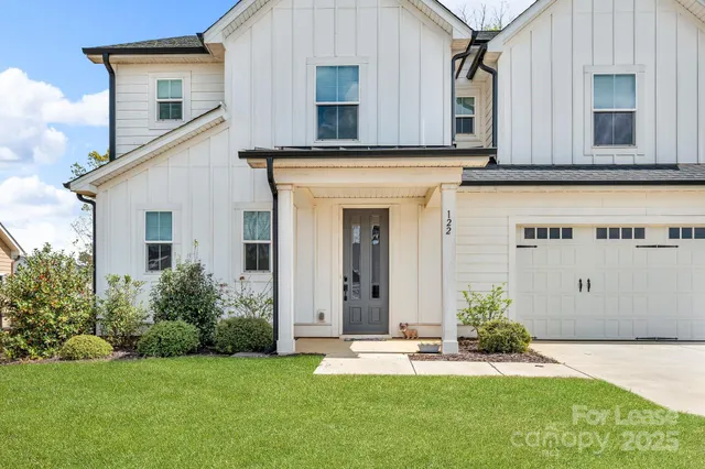 a kitchen with stainless steel appliances granite countertop a refrigerator a sink dishwasher a stove and white cabinets with wooden floor