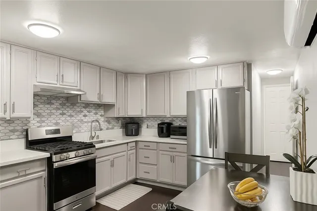 a kitchen with stainless steel appliances a refrigerator stove and sink
