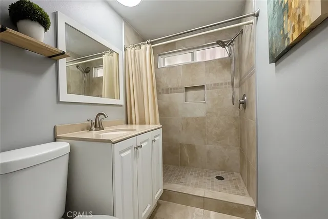 a bathroom with a shower sink vanity and toilet