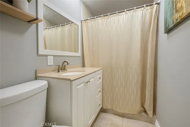 a utility room with a sink a toilet and a mirror