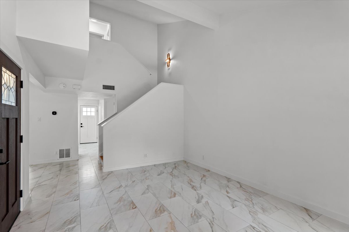 2500 Enfield Road, Unit 1 Austin, TX 78703 - Photo 6 of 26 A well-lit entry showcases a striking staircase and polished tiled flooring.