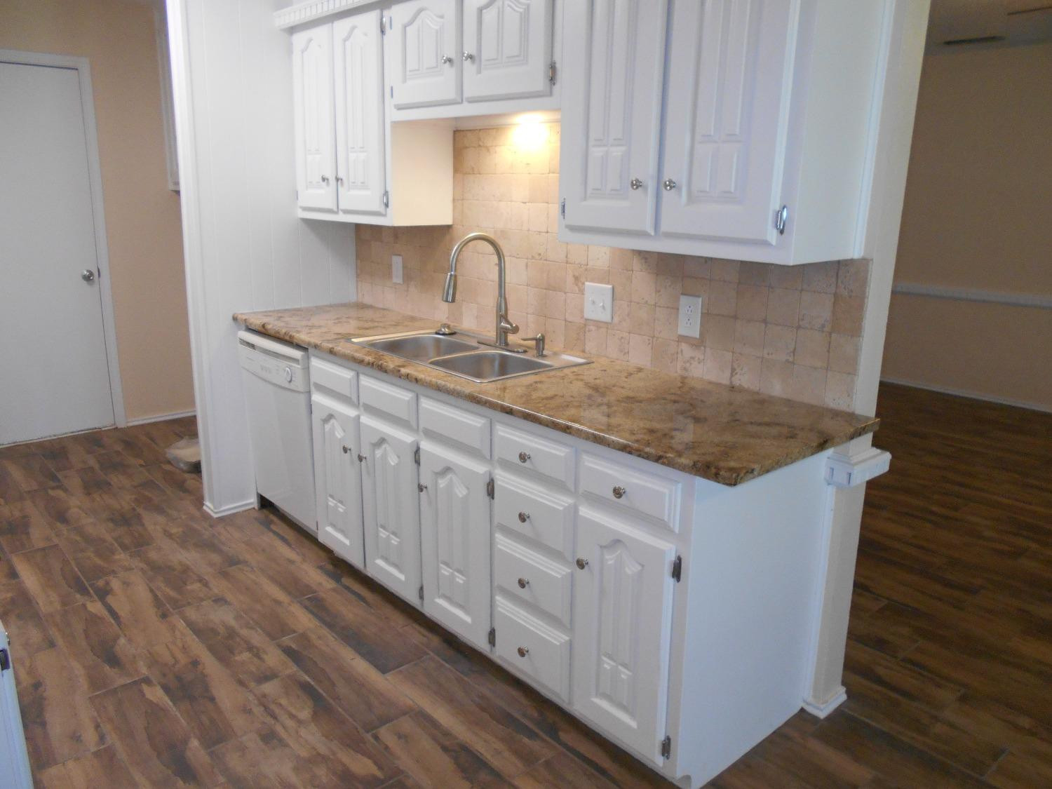 5739 Emory Street Lubbock, TX 79416 - Photo 6 of 14 a kitchen with stainless steel appliances granite countertop a sink stove and cabinets