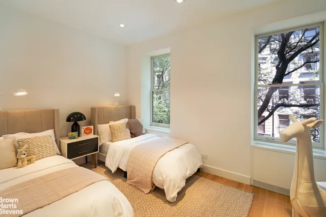 a bedroom with two beds and a window