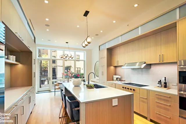 a kitchen with a sink a counter top space stainless steel appliances and cabinets