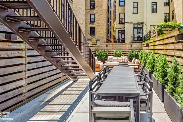 a view of a balcony with wooden floor and potted plants