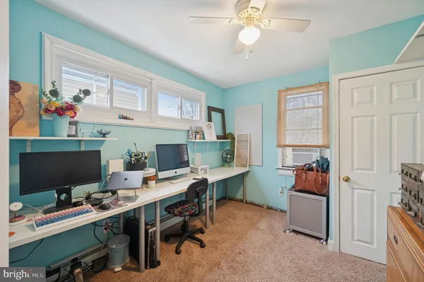 a view of a workspace with furniture and a window