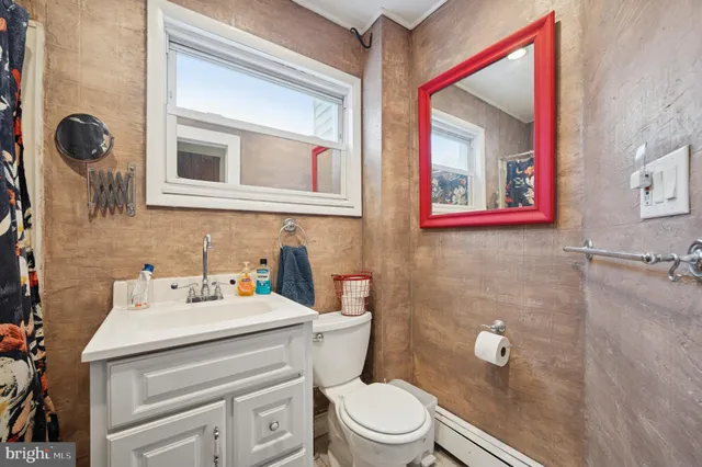 a bathroom with a toilet sink vanity and mirror