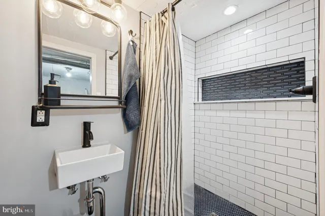 a bathroom with a sink a mirror and shower
