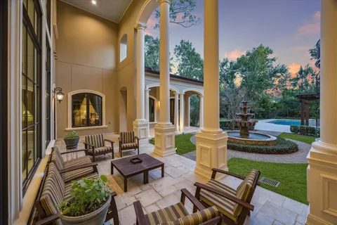 a front view of a house with garden and sitting area