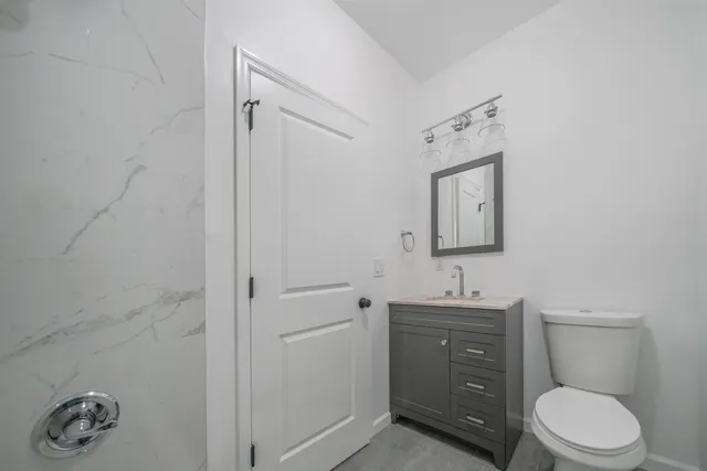 a bathroom with a toilet a sink and mirror