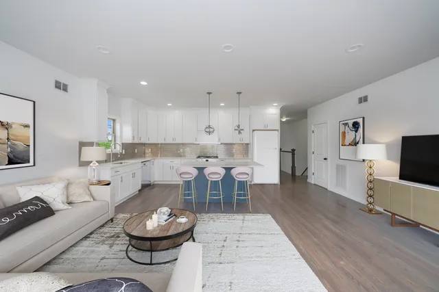 a living room with furniture a flat screen tv and kitchen view