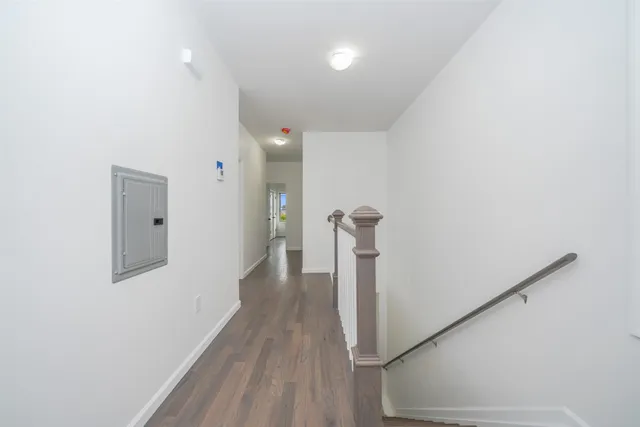 a view of a hallway with wooden floor and staircase
