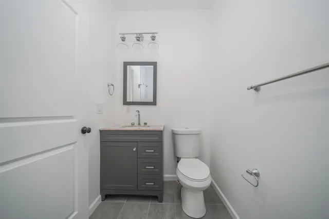 a bathroom with a toilet a sink and mirror