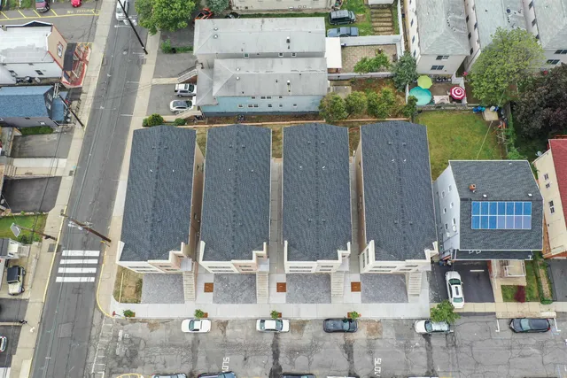 an aerial view of residential houses with outdoor space and street view