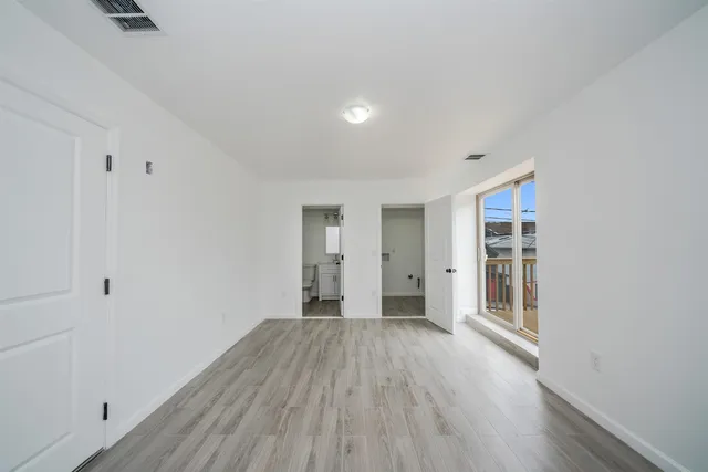 a view of a room with wooden floor and a window