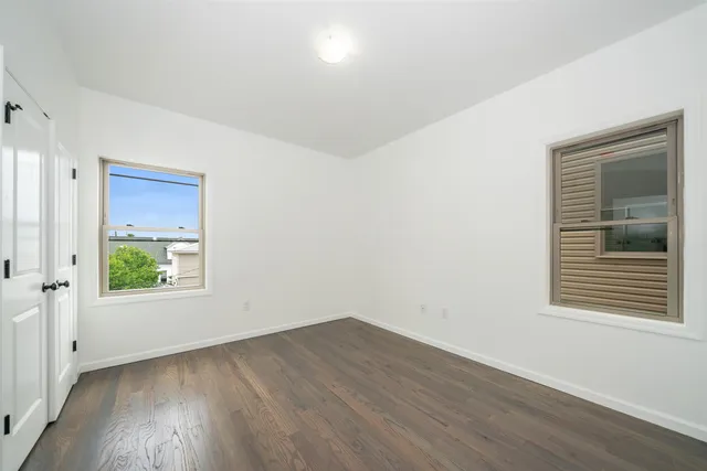 an empty room with wooden floor and a window