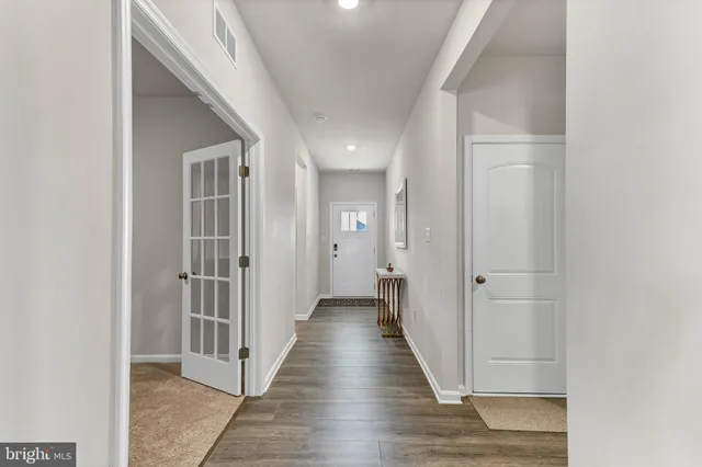 a view of a hallway with wooden floor