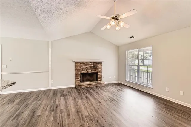 an empty room with windows fireplace and windows