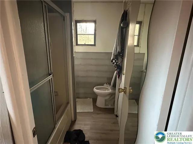 a bathroom with a toilet and a shower