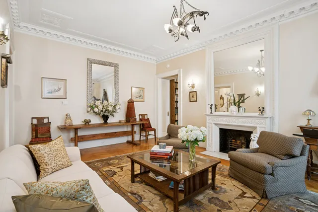 a living room with furniture a fireplace and a chandelier