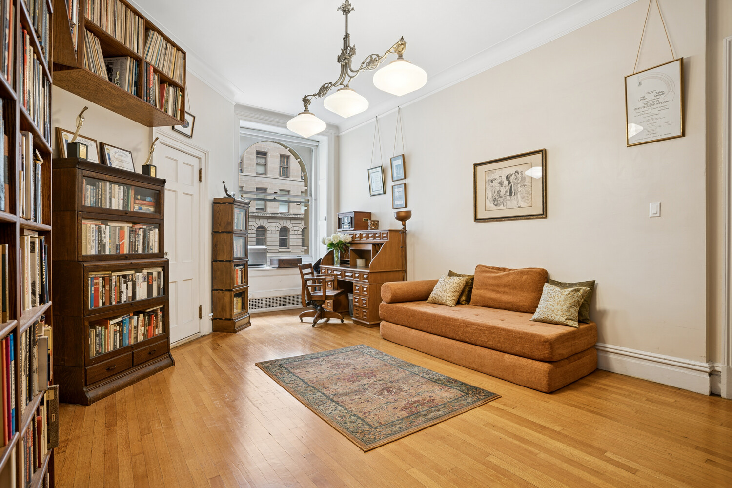 390 West End Avenue, Unit 3DN Manhattan, NY 10024 - Photo 4 of 8 a living room with furniture a bookshelf and a wooden floor
