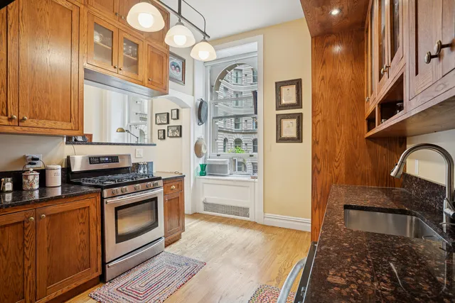 a kitchen with stainless steel appliances granite countertop a stove a sink and a refrigerator