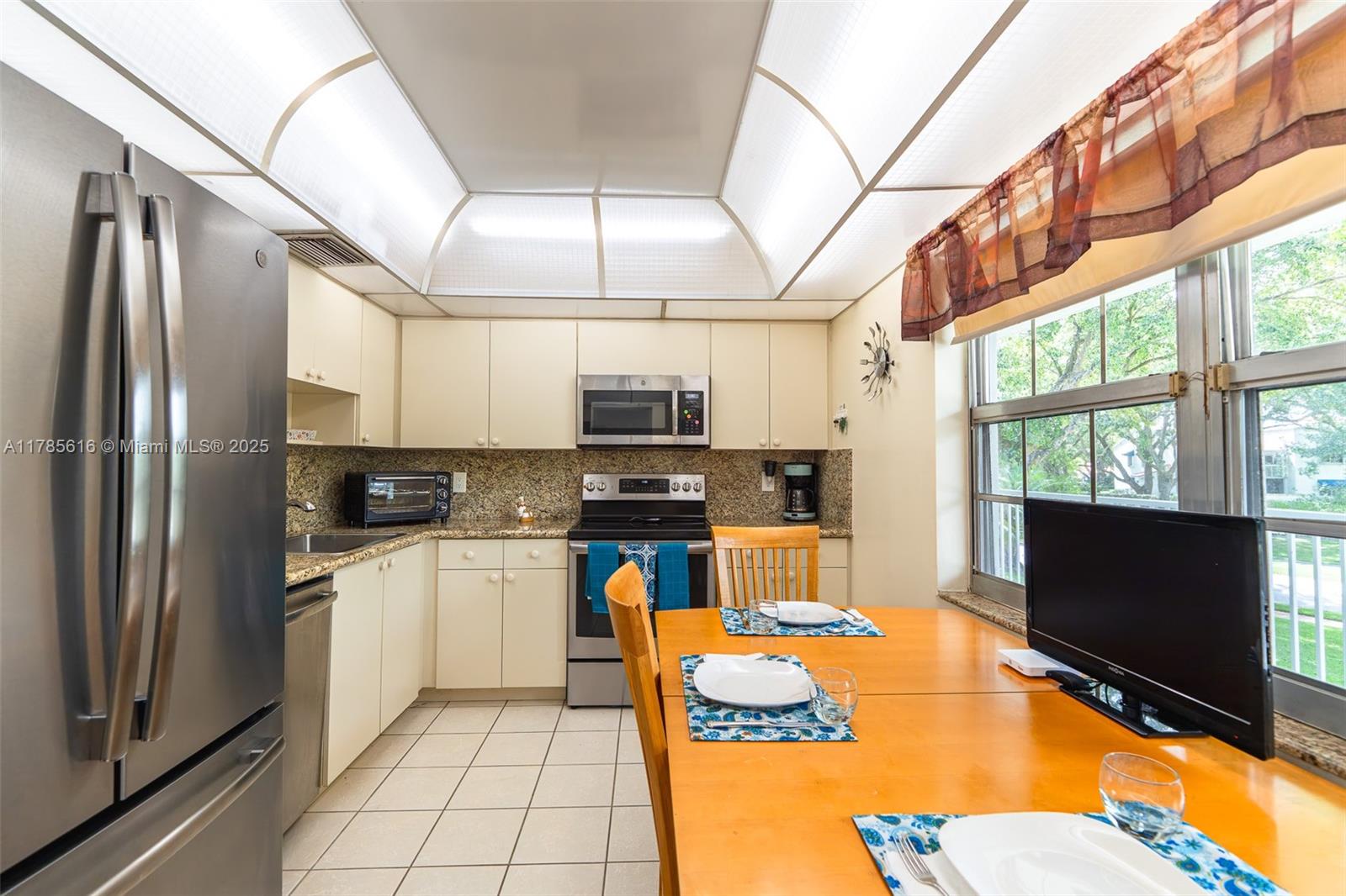 4221 West Palm Aire Drive, Unit 203 Pompano Beach, FL 33069 - Photo 21 of 39 a kitchen with stainless steel appliances granite countertop a refrigerator and a stove top oven