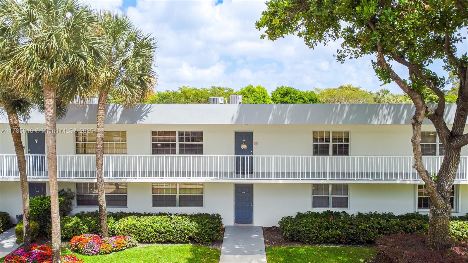 4221 West Palm Aire Drive, Unit 203 Pompano Beach, FL 33069 - Photo 10 of 39 a front view of a house with garden and trees