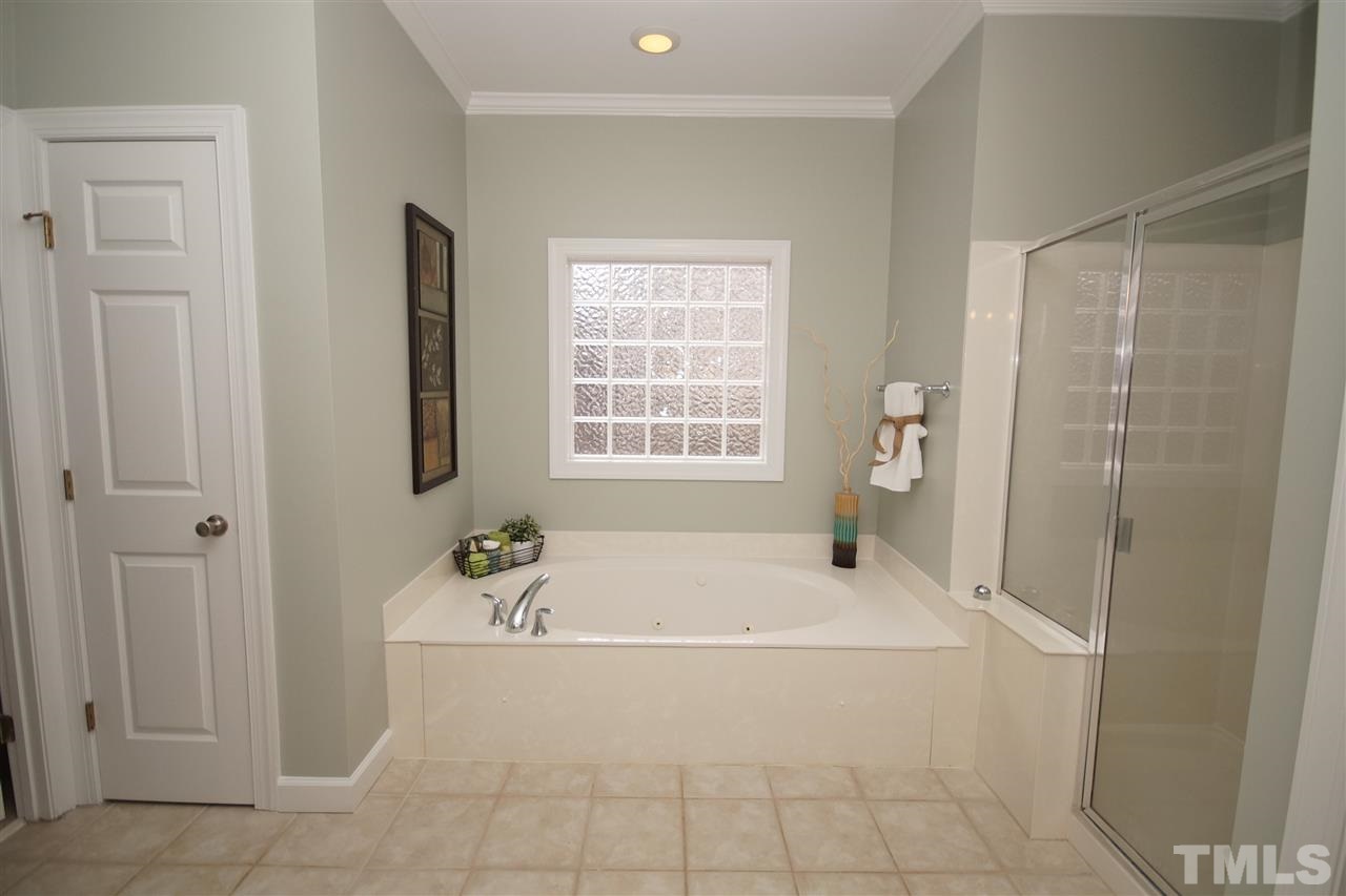 12736 Amoretto Way Raleigh, NC 27613 - Photo 13 of 25 a white bath tub sitting next to a window