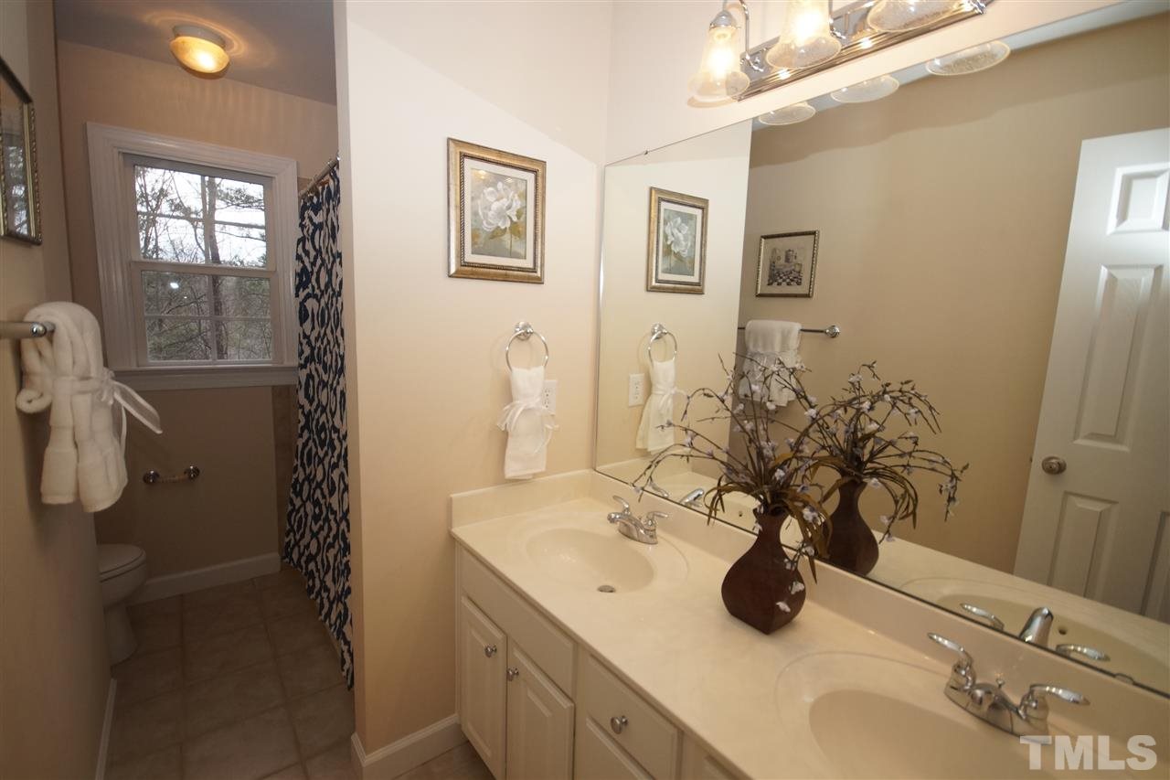 12736 Amoretto Way Raleigh, NC 27613 - Photo 17 of 25 a bathroom with a sink and a mirror