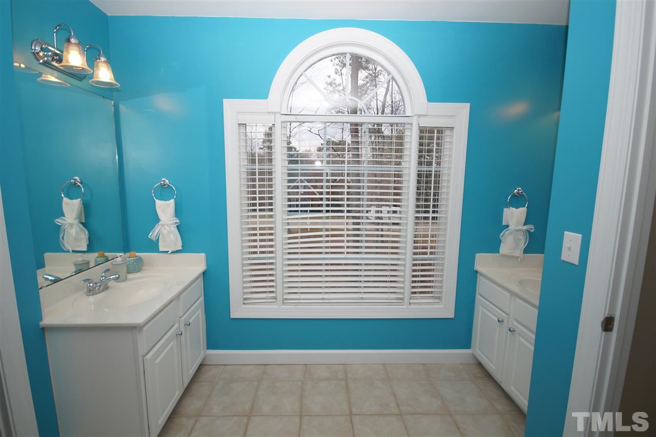 12736 Amoretto Way Raleigh, NC 27613 - Photo 21 of 25 a bathroom with a sink a mirror and a window