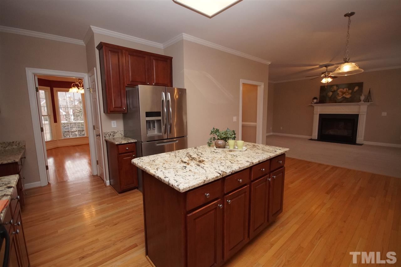 12736 Amoretto Way Raleigh, NC 27613 - Photo 9 of 25 a kitchen with stainless steel appliances granite countertop wooden cabinets a refrigerator and a stove