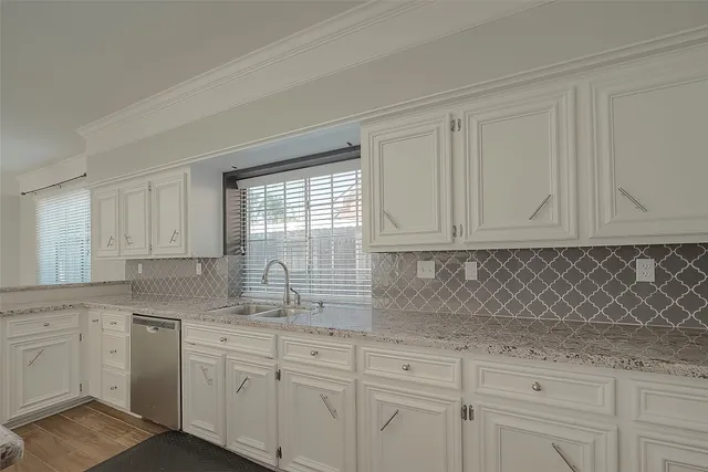 a kitchen with granite countertop white cabinets and white appliances