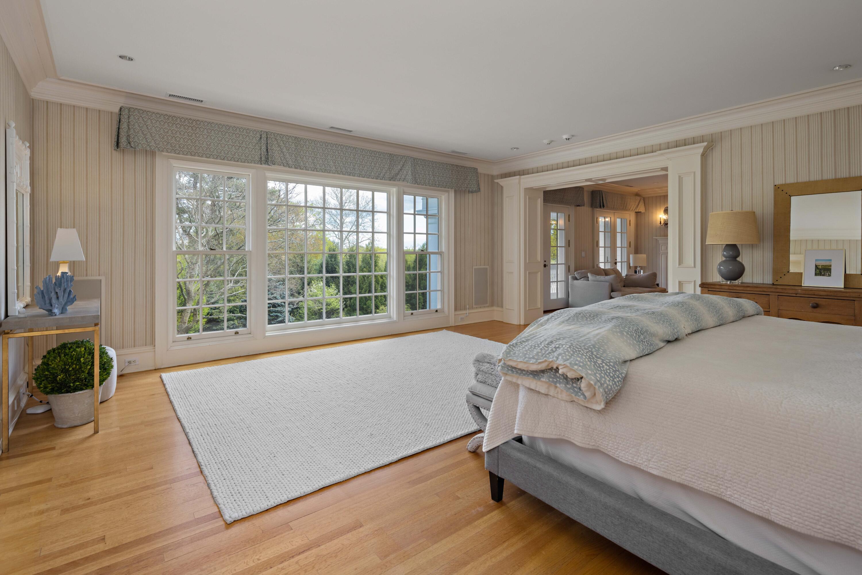 625 Oenoke Ridge New Canaan, CT 06840 - Photo 25 of 40 a spacious bedroom with a bed and wooden floor