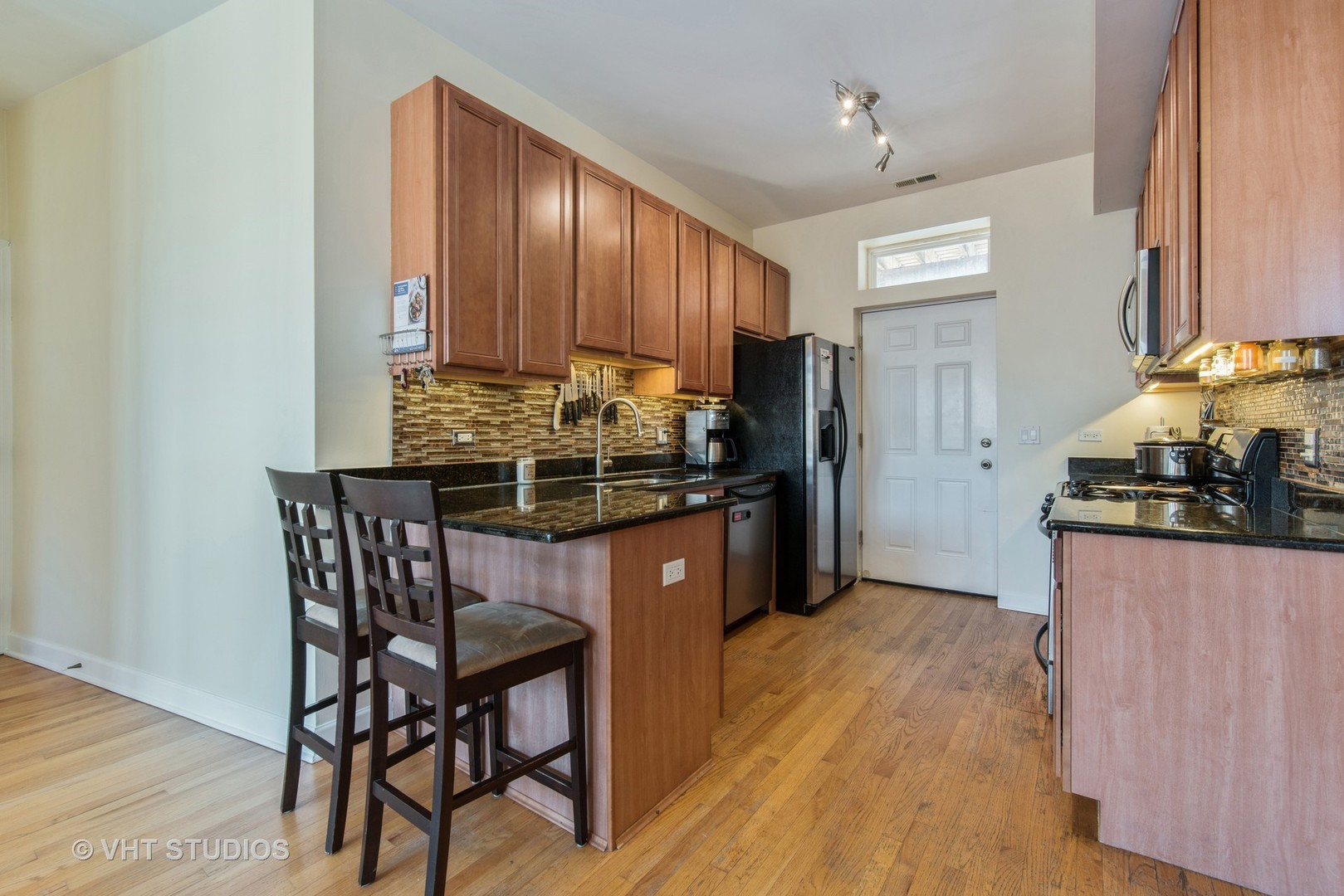 2010 North Spaulding Avenue, Unit 2 Chicago, IL 60647 - Photo 4 of 10 a kitchen with stainless steel appliances kitchen island granite countertop a stove refrigerator and cabinets