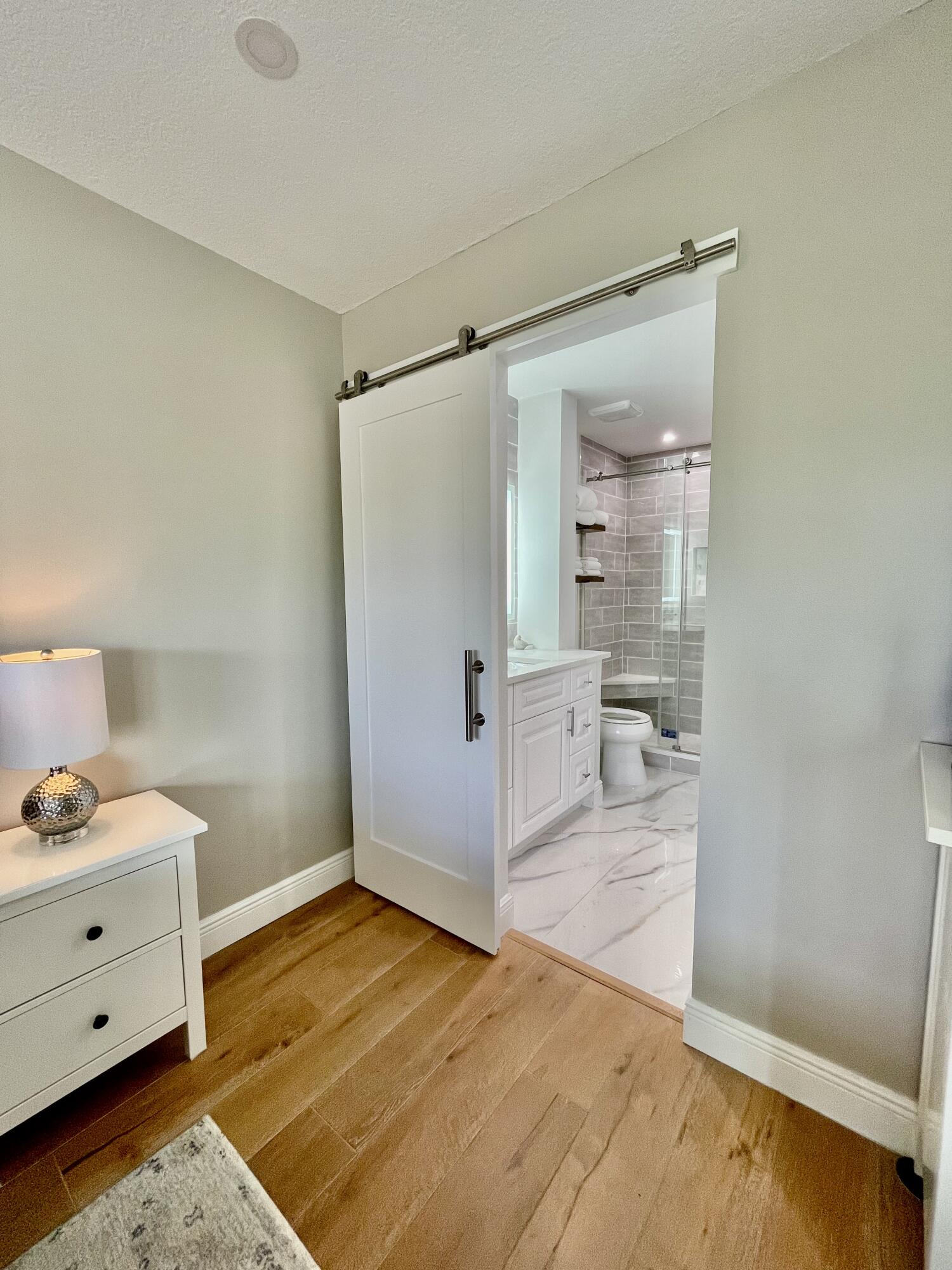 1030 Sugar Sands Boulevard, Unit 372 Riviera Beach, FL 33404 - Photo 15 of 45 Barn door to main bathroom