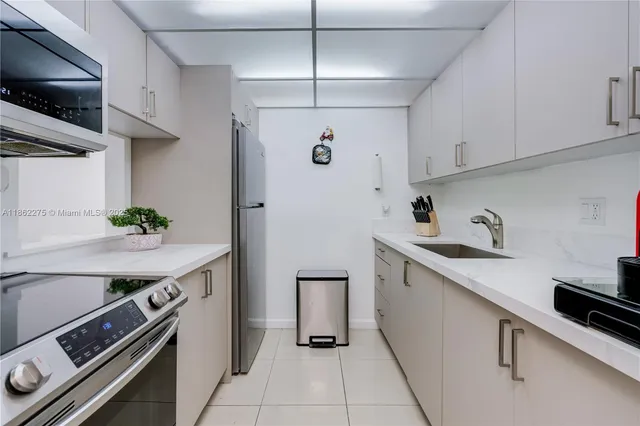 a kitchen with stainless steel appliances a sink a stove and refrigerator