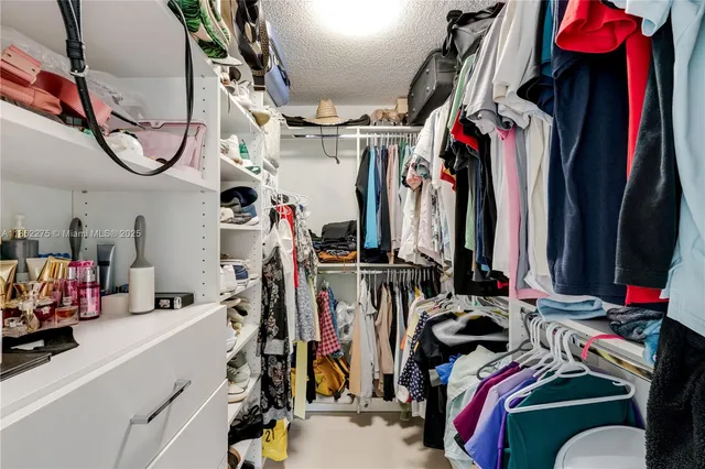 a view of walk in closet with clothes