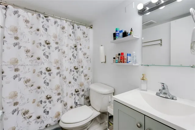 a bathroom with a sink a toilet and a shower curtain
