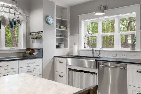 a kitchen with stainless steel appliances granite countertop a sink and wooden cabinets