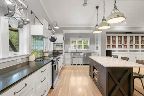 a large kitchen with kitchen island a large island in it