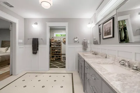 a bathroom with a granite countertop sink a mirror a vanity and shower