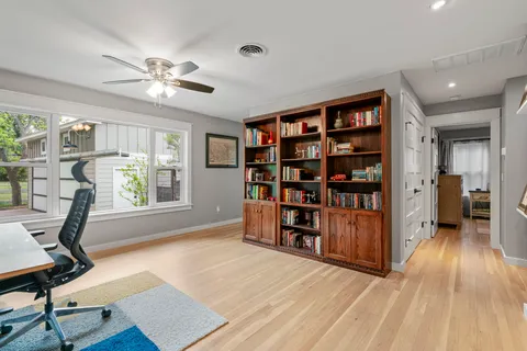 a view of a workspace with furniture and a window